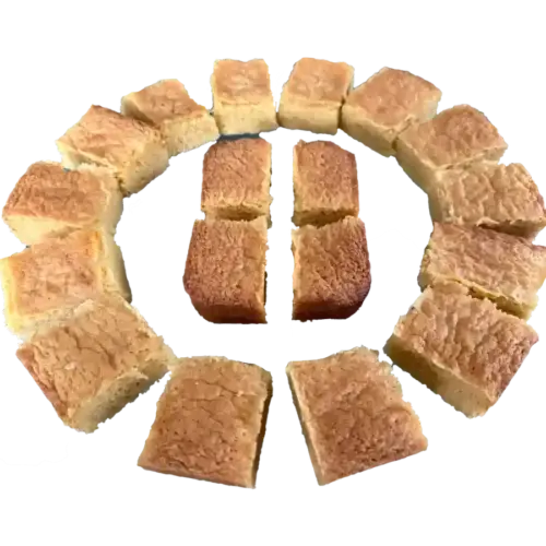 White chocolate blondies cut into pieces, arranged in a circle on a white background