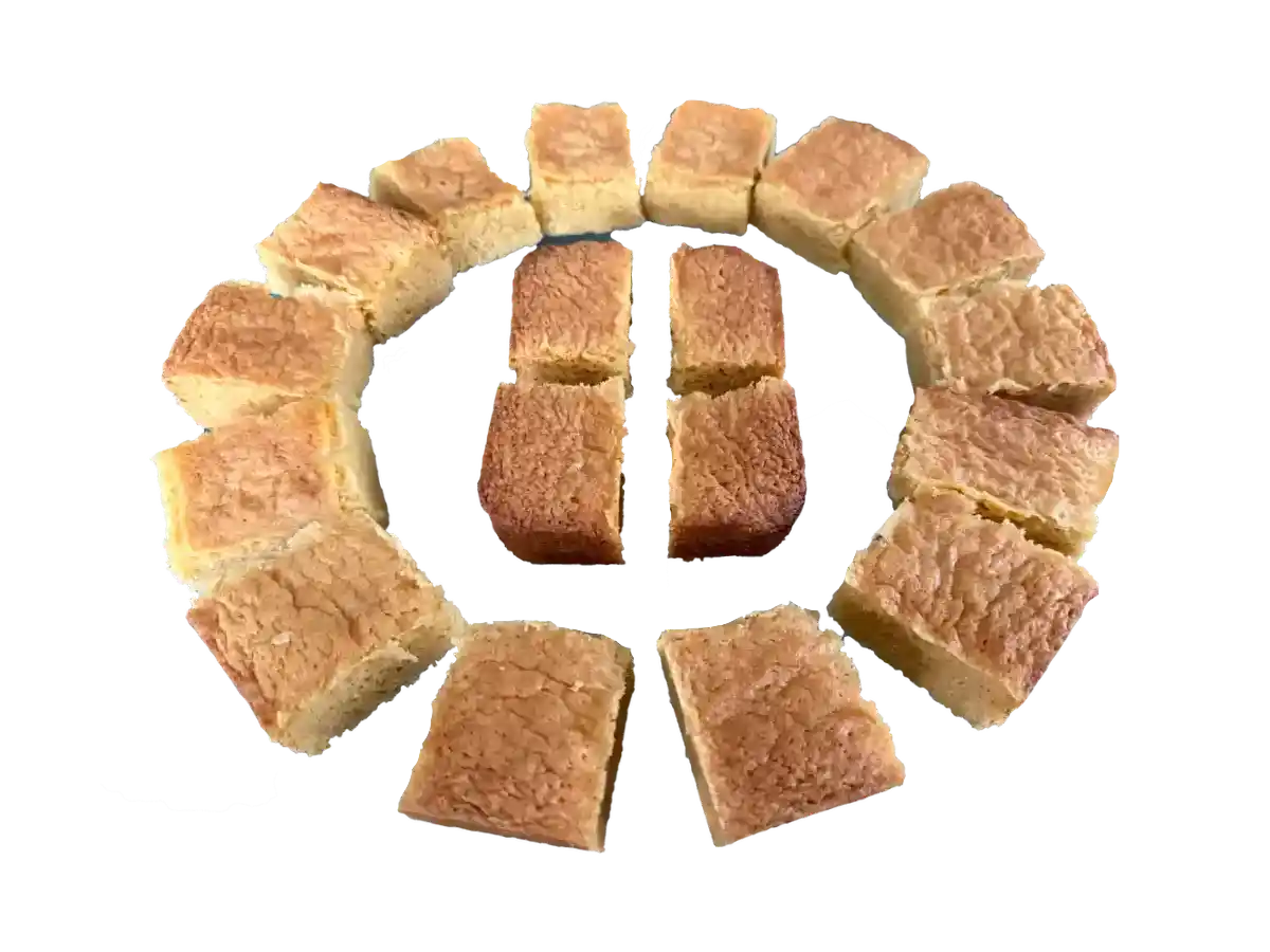 White chocolate blondies cut into pieces, arranged in a circle on a white background