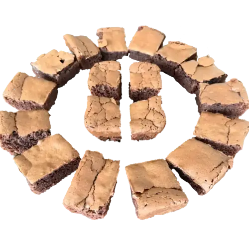 Chocolate brownies cut into pieces, arranged in a circle on a white background