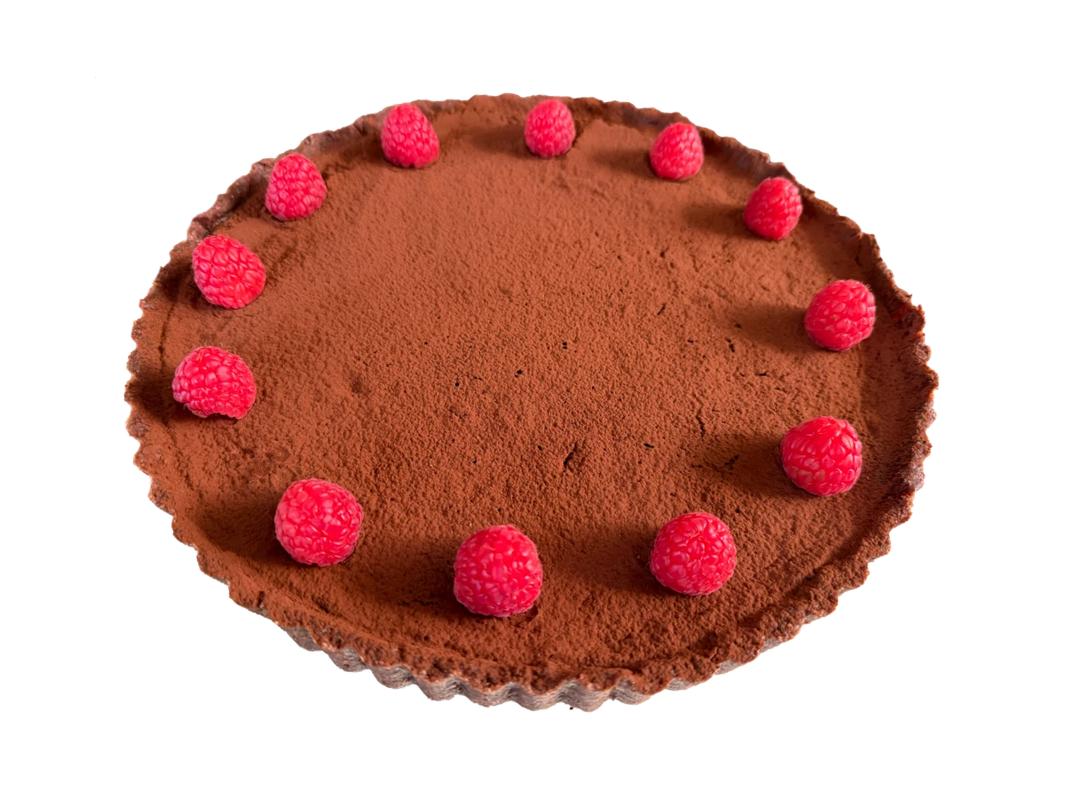 Schokoladentarte mit Kakaobestäubung und frischen Himbeeren auf dunklem Tarteboden