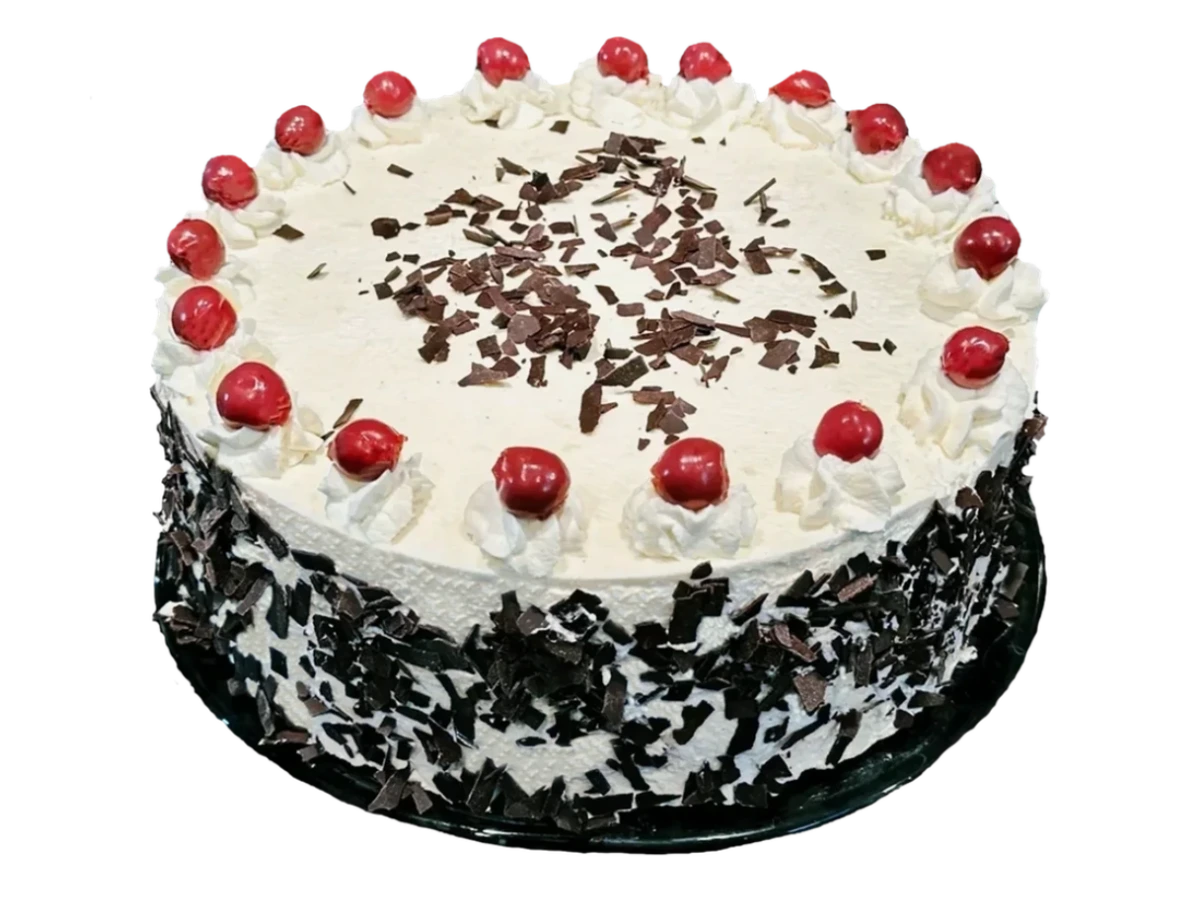 Black Forest cake with little whipped cream peaks, cherries and chocolate shavings on a cake stand