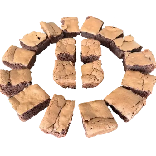 Schokoladen-Brownies in Stücke geschnitten, ringförmig auf weißem Hintergrund angeordnet